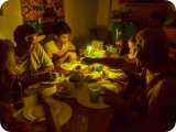 停電が続く中、ろうそくの灯を頼りに夕食を囲む家族。